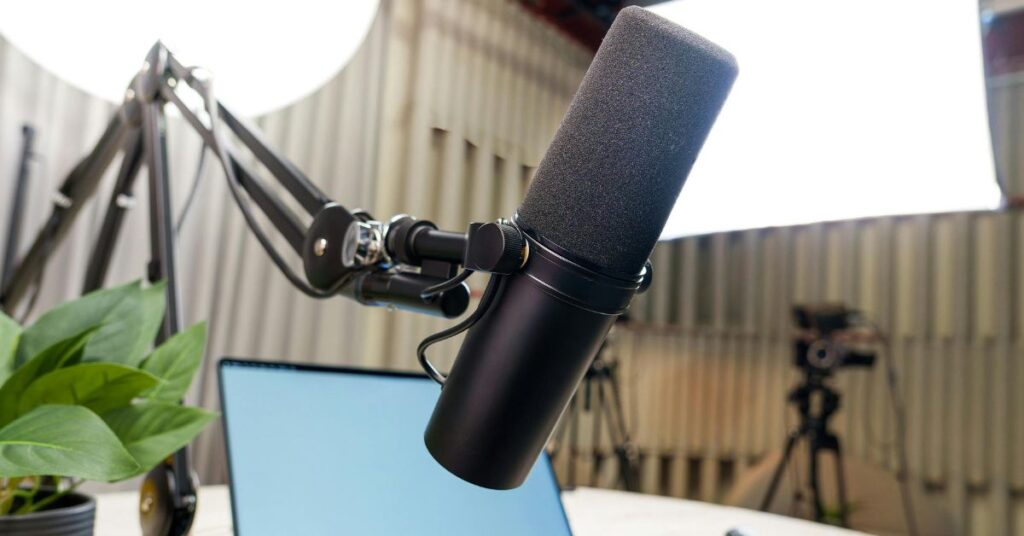 Professional podcast microphone with laptop and studio lighting, representing The Interworldradio Blog content.